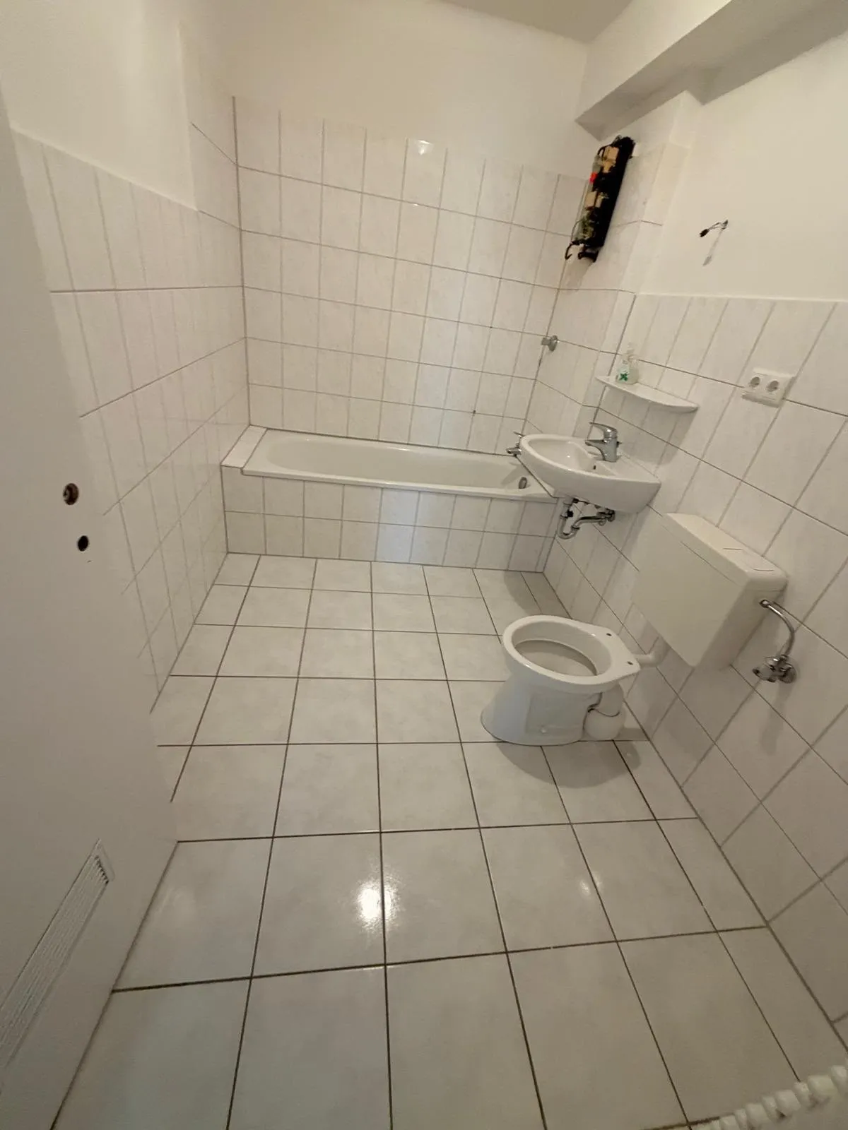Nachher: dasselbe Badezimmer leer und sauber, Fliesen glänzen