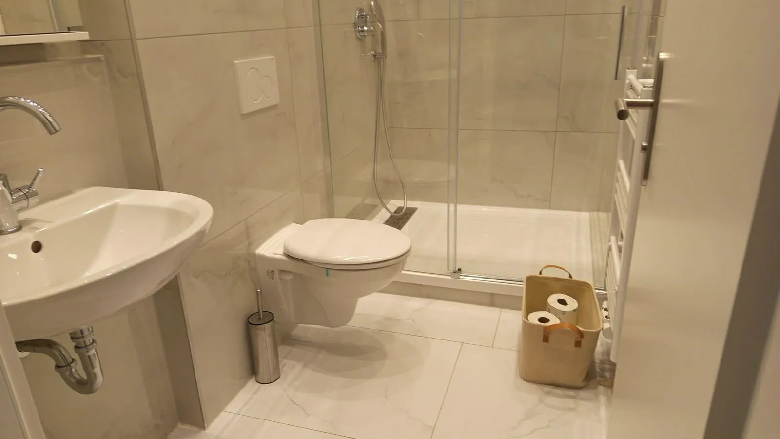 Modernes Badezimmer mit Dusche, Waschbecken und WC nach der Reinigung