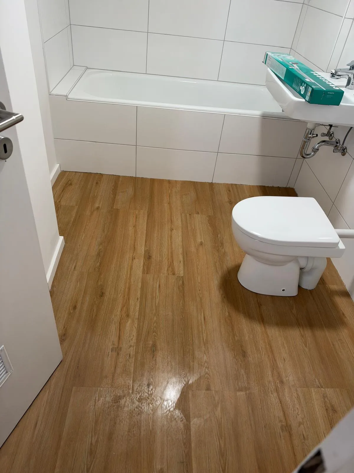 Bad mit Badewanne und frisch gewischtem Holzboden