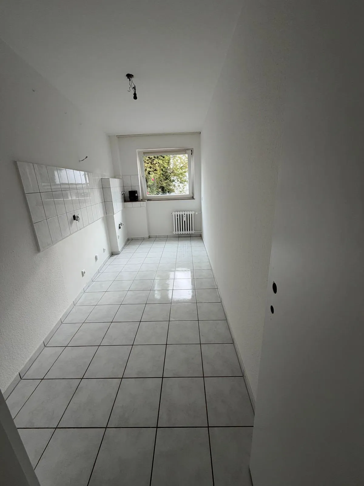 Leere, gereinigte Küche mit Fliesenboden vor der Wohnungsübergabe