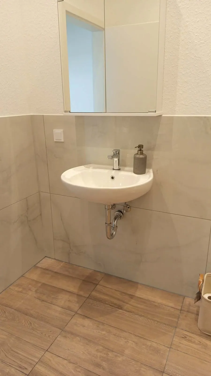 Sauberes Waschbecken mit Spiegelschrank